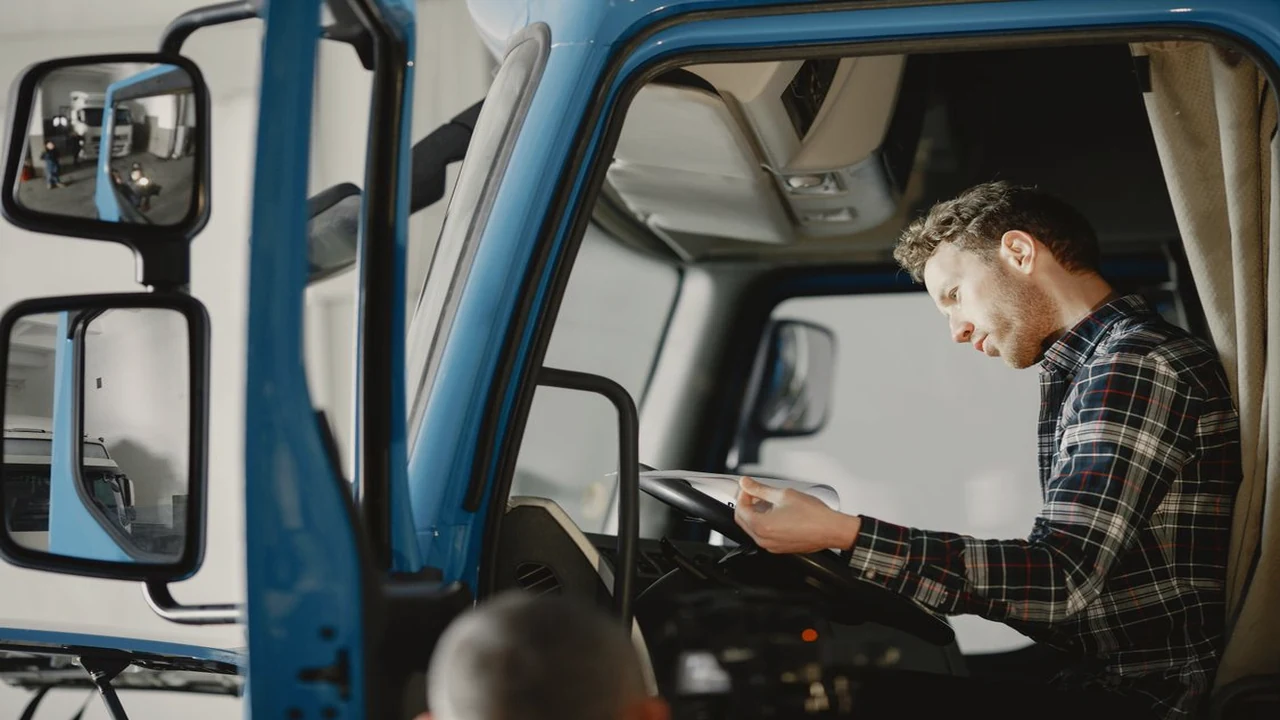 Mechanic reading a checklist inside a truck cab